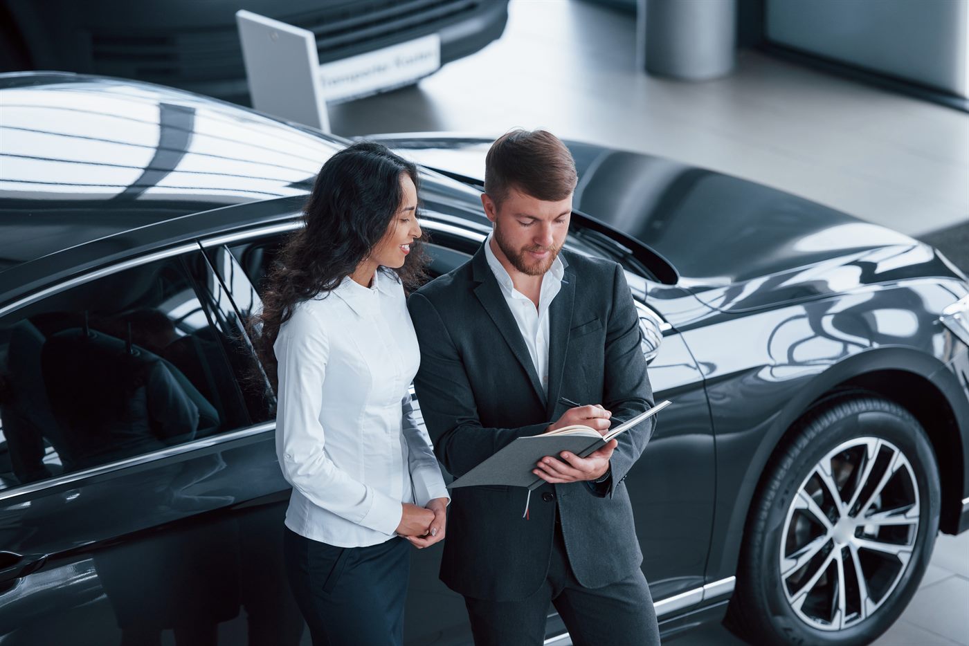 Two CrashCall team members reviewing paperwork by a vehicle