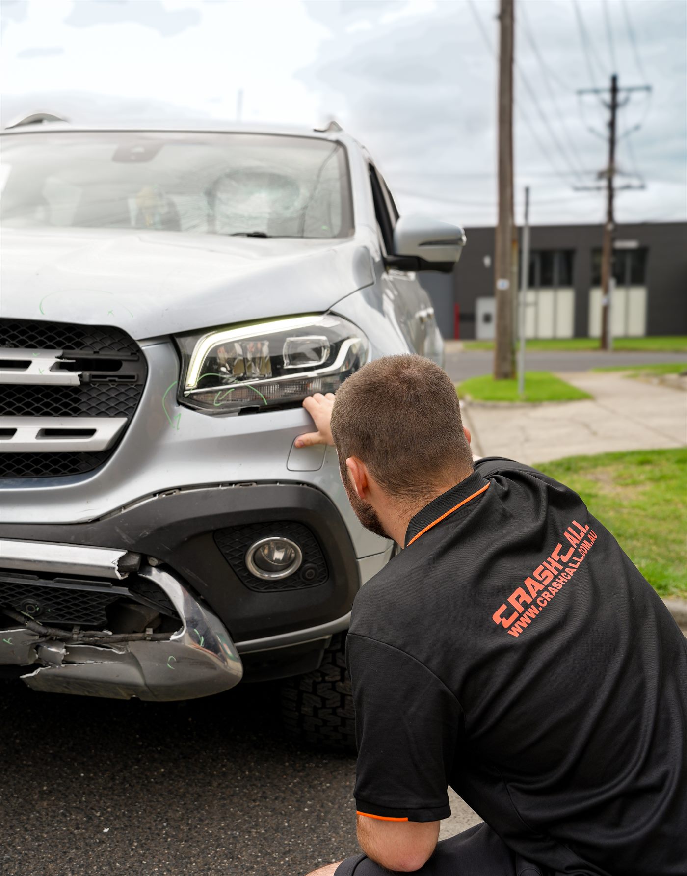 CrashCall team member inspecting damage on a customer's vehicle